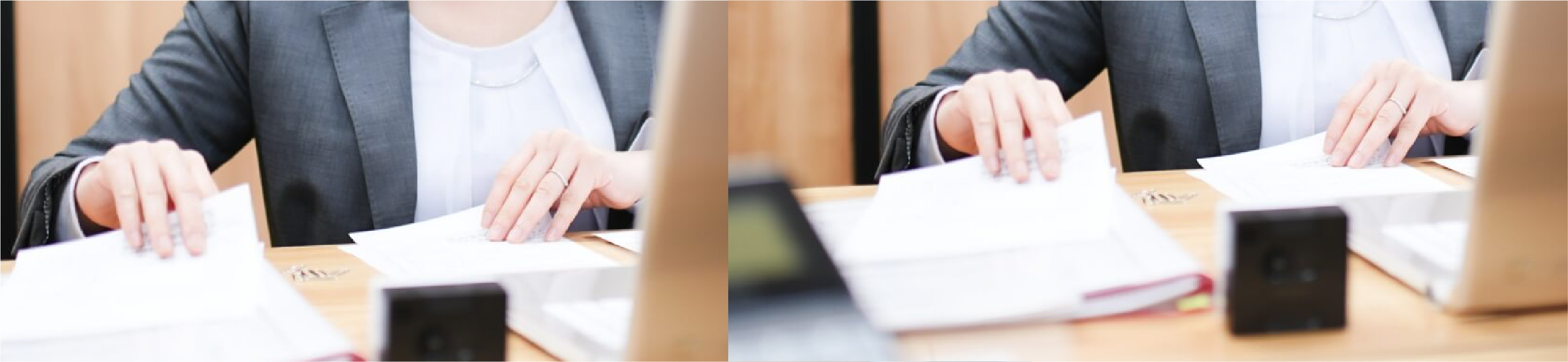 スーツを着た人物がデスクで書類を整理している様子。机の上にはノートパソコンや書類が広げられており、ビジネスシーンを表している。